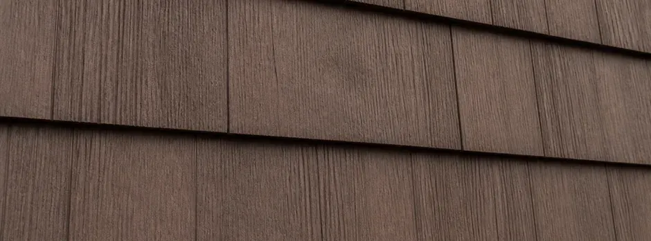 Close-up of brown cedar-look shake siding.