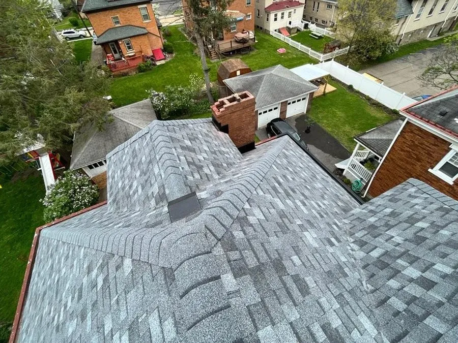 Finished brick colonial roof with a complex hip-and-valley shingle system after a full replacement.