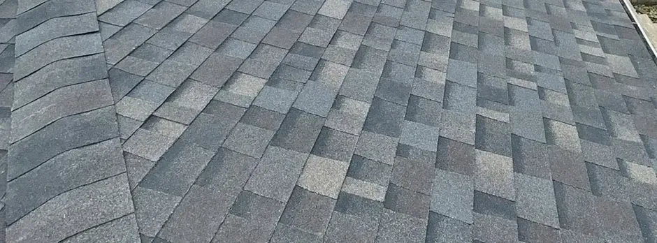 Close-up texture of gray architectural asphalt shingles.