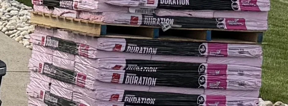 Pallets of roofing shingle bundles staged and ready for a same-day job.