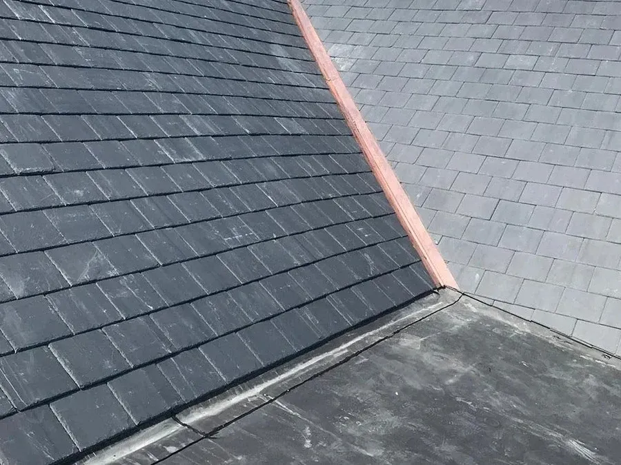 Close-up of copper valley flashing where two roof planes meet, a common source of leaks when it fails.