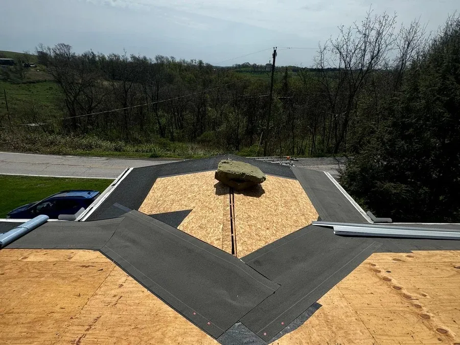Aerial view of complex plywood roof decking with multiple valley intersections framed before shingles are installed.
