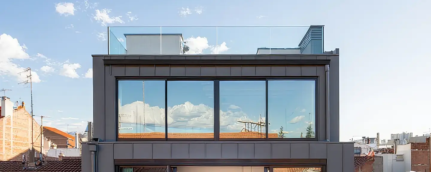 Modern multi-story commercial building with dark cladding and large glass windows.