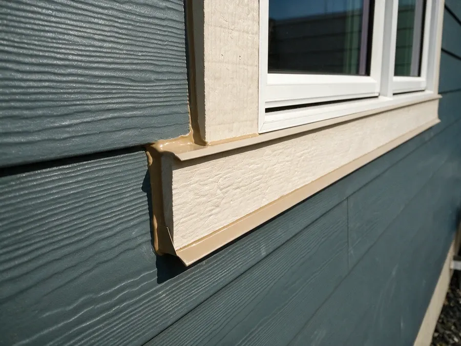 Close-up of a clean, properly sealed caulk joint where siding meets a window trim.