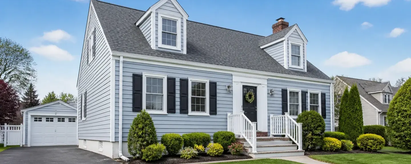 Blue-gray cape cod style American home with vinyl siding.