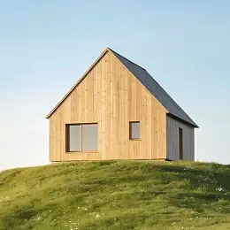 Modern wooden house with a steep pitched roof on a grassy hill.